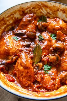 a close up of a bowl of food with meat and vegetables in it on a table