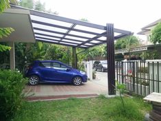 a small blue car parked in front of a house with a pergolated roof