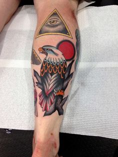 a man with a tattoo on his leg has an eagle and pyramids in the background