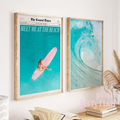 two framed surf posters hang on the wall above a desk with books and a plant