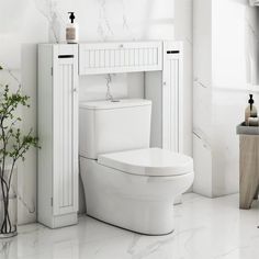 a white toilet sitting in a bathroom next to a tall cabinet and vase with flowers