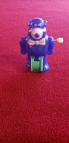 a toy bear with a toothbrush in it's mouth on a red carpet