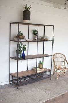 a shelf with potted plants on it next to a wicker chair