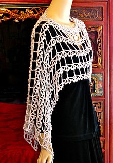 a mannequin wearing a black dress and white crochet shawl