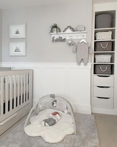 a baby's room is decorated in white and gray with lots of storage space