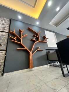 a tree made out of wood sitting on top of a floor next to a wall