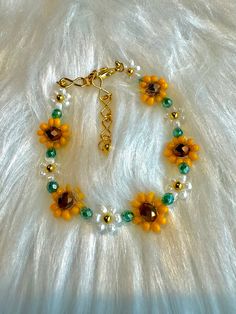 a bracelet with sunflowers and glass beads on a white furnishce background