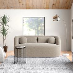 a living room filled with furniture and a large window next to a rug on top of a hard wood floor