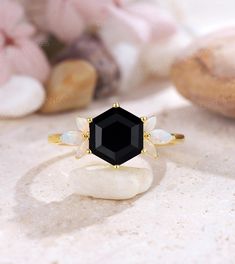 an image of a ring with black stone and opal stones on it's sides