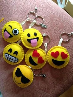 several smiley face key chains on a pink surface