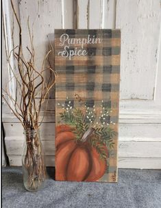 a pumpkin spice sign next to a vase with flowers