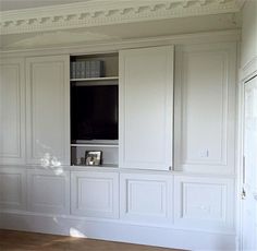 an empty living room with white walls and built in bookshelves