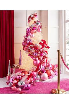 a pink christmas tree with ornaments on it