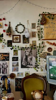 a wall covered in pictures and photos next to a chair