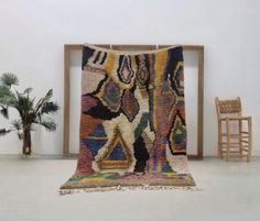 a large rug is on the floor in front of a chair and potted plant