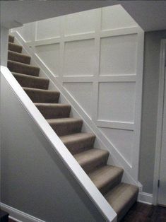 an empty staircase in a house with white walls and wood flooring on either side