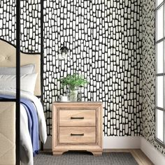 a bedroom with black and white patterned wallpaper