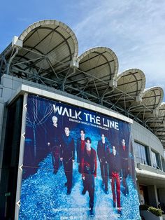 a large billboard on the side of a building advertising walk the line with men in black