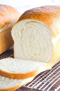 two loaves of bread sitting on top of a table next to a cooling rack