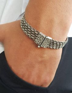 Knitted mens cuff bracelet is braided from 1000K silver wires with embroidered clasp. This is a special technique, first we make threads from silver and then we knit them ONE by ONE on hand by using ancient Lydian techniques. Definitely an unique gift for grooms, will make him feel special. Timeless and  never go out of style. It is comfortable to use and very chic. Designer jewelry gift for him. It will be a great addition to your jewelry collection. Silver is oxidized than polished to give a lovely sparkle.  2nd bracelet as shown in the picture will be sent as a gift with your order. It will be shipped in a giftbox ready to give.  Type: Kazaziye Sterling Silver Bracelet For Him Metal: 1000 Sterling Silver( only lock part is 925 sterling silver), Silver is oxidized to make grey Bracelets Personalized Silver Bracelets, Make Him Feel Special, Mens Cuff Bracelets, Men Chain, Mens Cuff, Mens Bracelet Silver, 1st Anniversary Gifts, Engraved Bracelet, Elegant Bracelet