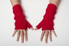 two hands wearing red knitted gloves on top of each other