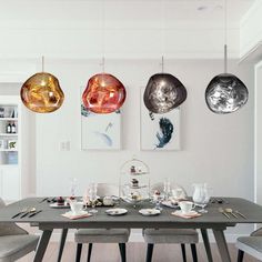 a dining room table with plates and bowls on it, hanging from the ceiling above