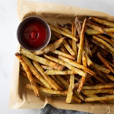 french fries with ketchup in a basket on a table