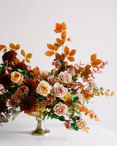 a vase filled with lots of flowers on top of a table