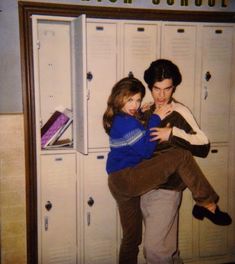 two girls hugging each other in front of lockers