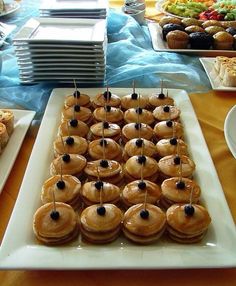 there are many donuts on the table with toothpicks stuck in them to eat