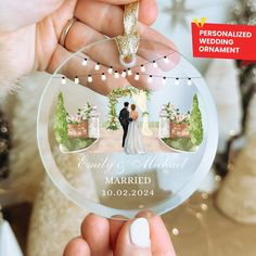 a person holding a glass ornament with a wedding photo on the front and back