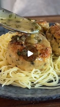 a plate with spaghetti, meatballs and sauce being served on it by a knife