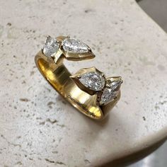 two gold rings with diamonds sitting on top of a table