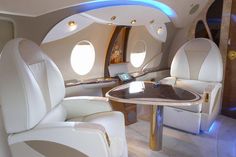 the inside of an airplane with two seats and a table in front of it that is lit up