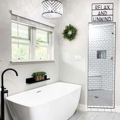 a white bath tub sitting under a window next to a sink