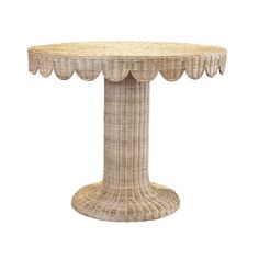 a wicker table with scalloped edges on the top and an oval base