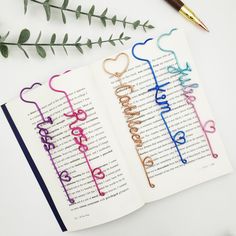 two bookmarks with the word happy written on them next to a pen and flowers