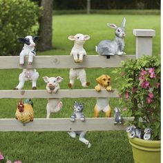 several stuffed animals are placed on a fence