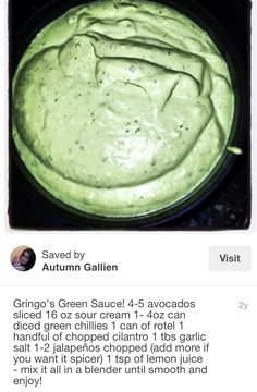 a bowl filled with green sauce sitting on top of a counter next to a black plate