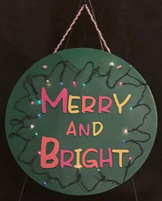 a merry and bright sign hanging from the side of a building