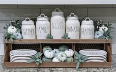 the kitchen counter is decorated with white pumpkins and greenery for fall decorating