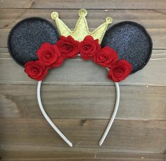 a mickey mouse ears headband with red roses on it and a gold crown over the top