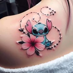 a woman with a tattoo on her back has a flower in the shape of a cartoon character