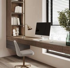 a desk with a computer on it in front of a book shelf and window sill