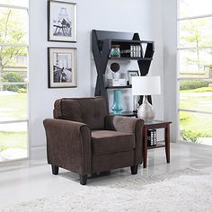 a living room with a brown chair and two pictures on the wall next to it