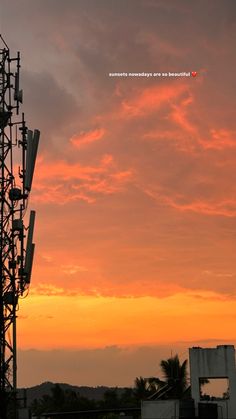 the sun is setting behind a tower with cell phones on it's sides and palm trees in the foreground