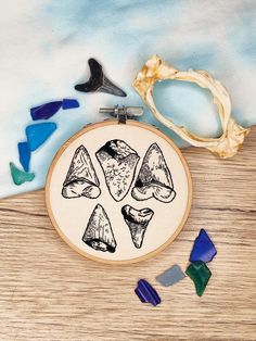 "Make your own colourful hand-embroidered wall art with this in-depth PDF embroidery pattern. This pattern will help you to create my popular \"Shark Week\" vintage inspired sharks tooth design. This is an beginner/intermediate ability level pattern. I would recommend you have some experience using split stitch and/or backstitch with this pattern. You can use whatever colours and stitches you like, to create your own individual piece of art, however I do provide suggestions of colours through visual photographic and digitally drawn aids, together with the stitches I have used so you can match the picture. This design was originally designed for a 4 inch hoop. This has a pre-sized 4-inch and 6-inch template included, as well as the original design in a resizable bitmap file so you can adjus Whale Shark Embroidery, Shark Embroidery Pattern, Stingray Embroidery, Tooth Embroidery, Shark Embroidery, Embroidered Whale, Sharks Tooth, Sharks Teeth, Pdf Embroidery Pattern