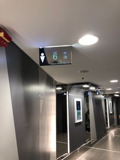 an empty hallway with some signs on the wall and lights in the ceiling above it