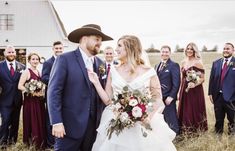 a bride and groom standing in front of their wedding party