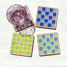 four different colored glass coasters sitting next to each other on top of a table